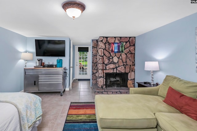 bedroom featuring light tile patterned flooring and a stone fireplace