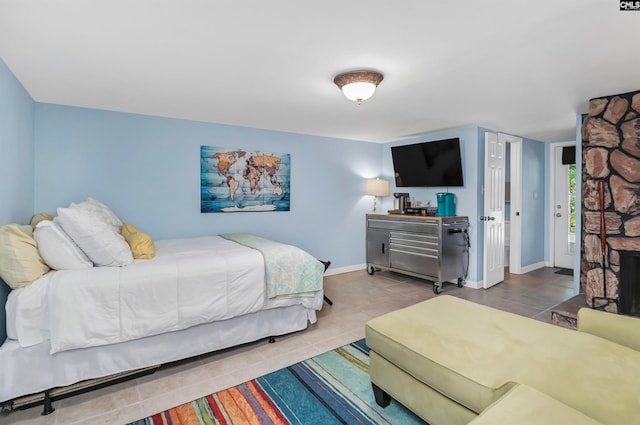 bedroom featuring a fireplace and light tile patterned floors