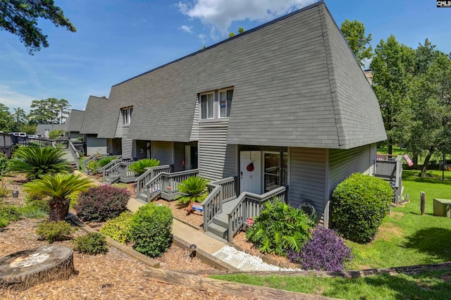 back of property featuring a yard and covered porch