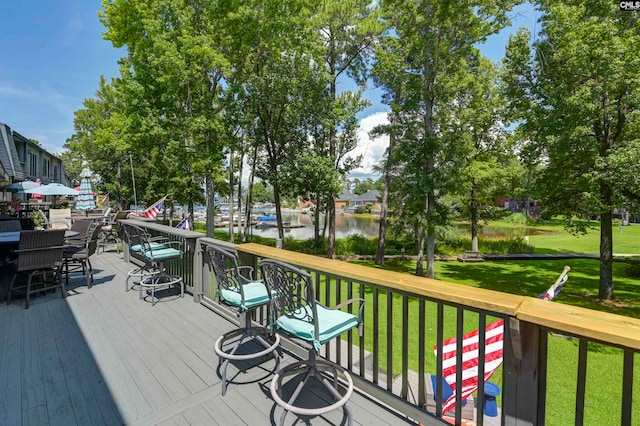 deck with a yard and a water view