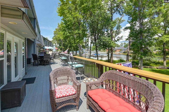 wooden terrace with a water view and french doors