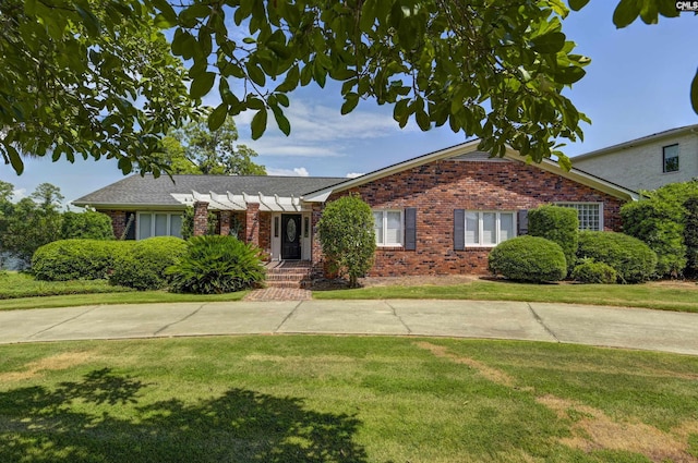 ranch-style house featuring a front yard and brick siding