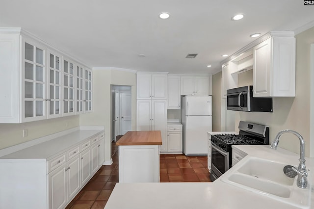 kitchen featuring dark tile patterned floors, stainless steel appliances, and white cabinetry