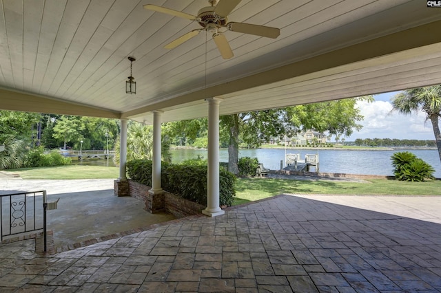 view of patio with a water view, ceiling fan, and a boat dock