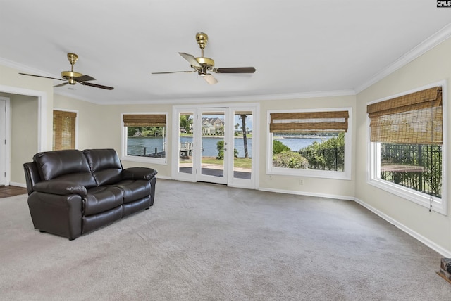 carpeted living room with ornamental molding, a water view, and a wealth of natural light