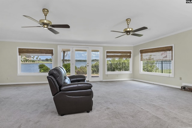 living area featuring plenty of natural light, carpet, and ornamental molding