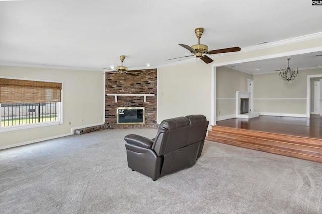 living room with a fireplace, carpet, ceiling fan with notable chandelier, brick wall, and ornamental molding