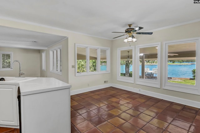 interior space with sink, plenty of natural light, ceiling fan, and dark tile patterned flooring