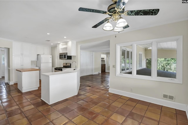 kitchen featuring baseboards, appliances with stainless steel finishes, visible vents, and white cabinetry