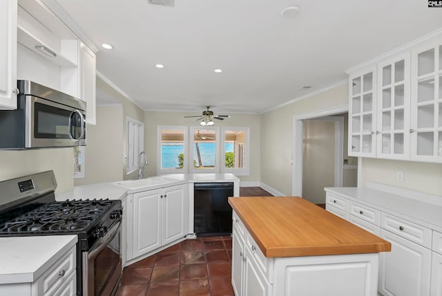 kitchen featuring dark tile patterned floors, stainless steel appliances, sink, white cabinetry, and ceiling fan