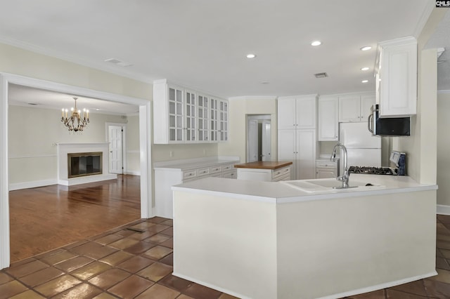 kitchen with glass insert cabinets, recessed lighting, white cabinetry, and crown molding