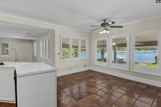 interior space featuring baseboards, light countertops, a sink, and crown molding