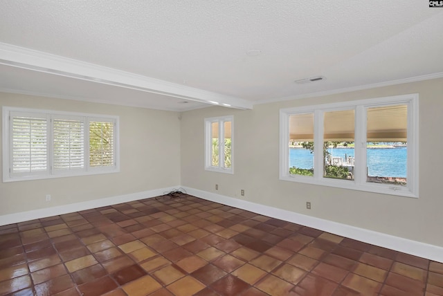 empty room featuring dark tile patterned floors, beamed ceiling, and ornamental molding