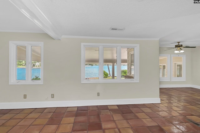 tiled empty room with a textured ceiling, a healthy amount of sunlight, ceiling fan, and beamed ceiling