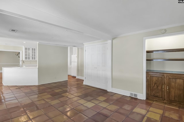 unfurnished room featuring ornamental molding, visible vents, a sink, and baseboards