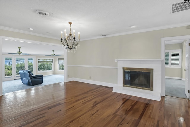 unfurnished living room featuring a fireplace, visible vents, wood finished floors, and ornamental molding