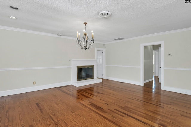 unfurnished living room featuring a textured ceiling, crown molding, hardwood / wood-style floors, and a chandelier