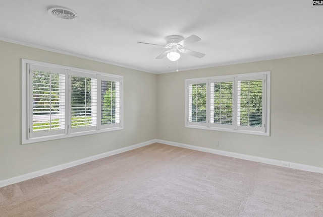 unfurnished room with ornamental molding, a healthy amount of sunlight, light colored carpet, and ceiling fan