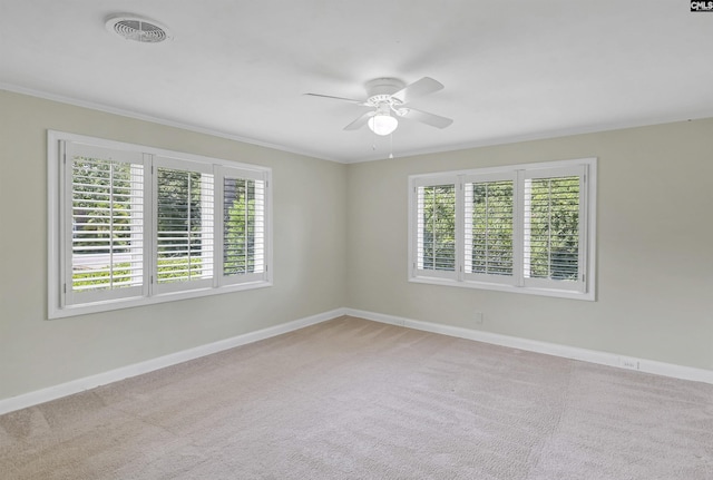 carpeted empty room with plenty of natural light, visible vents, ceiling fan, and baseboards