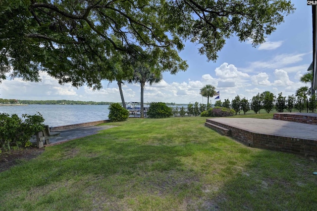 view of yard with a water view and fence