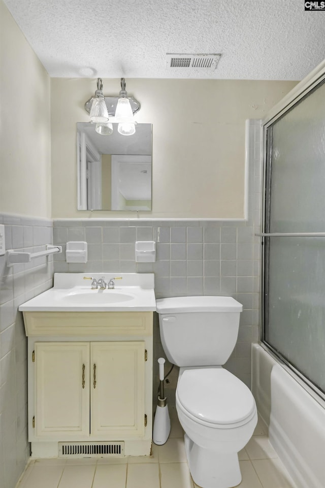 full bathroom featuring a textured ceiling, tile patterned flooring, and visible vents