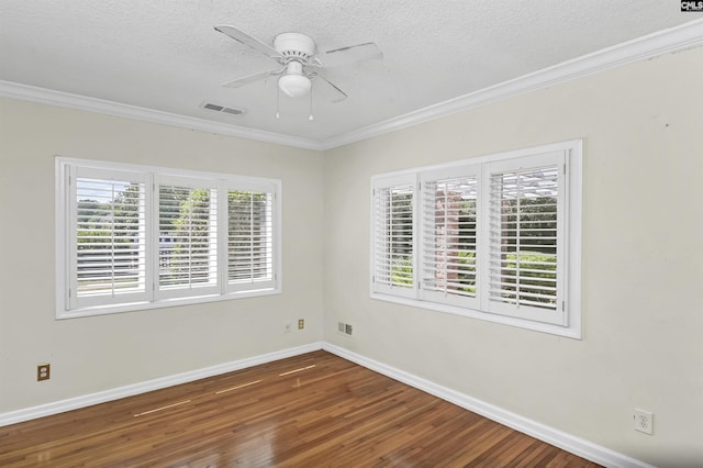 empty room with visible vents, ornamental molding, ceiling fan, wood finished floors, and baseboards