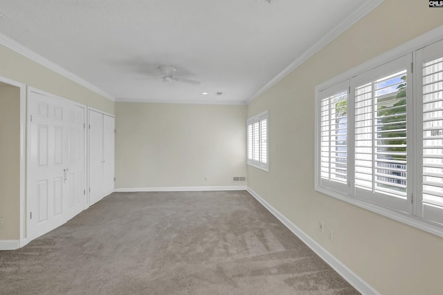 unfurnished bedroom with carpet flooring, crown molding, and baseboards