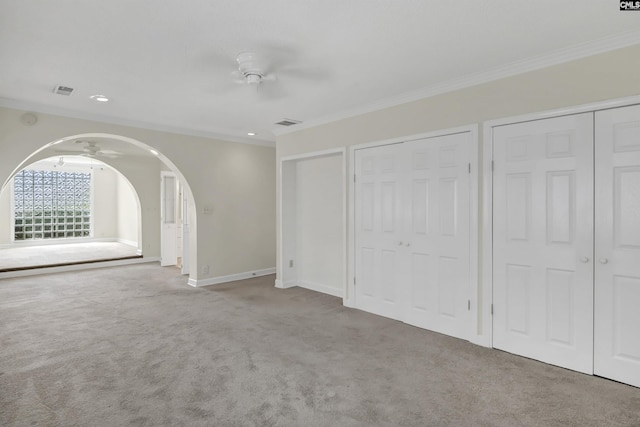 interior space featuring arched walkways, ornamental molding, carpet, and baseboards