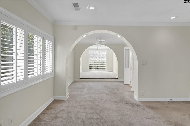 corridor featuring arched walkways, carpet flooring, visible vents, baseboards, and ornamental molding