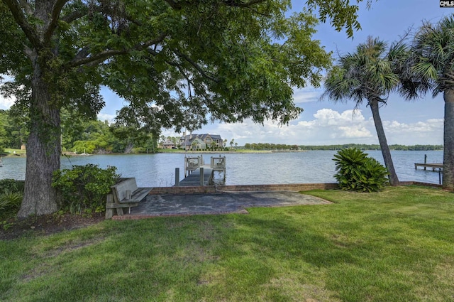 dock area featuring a water view and a lawn