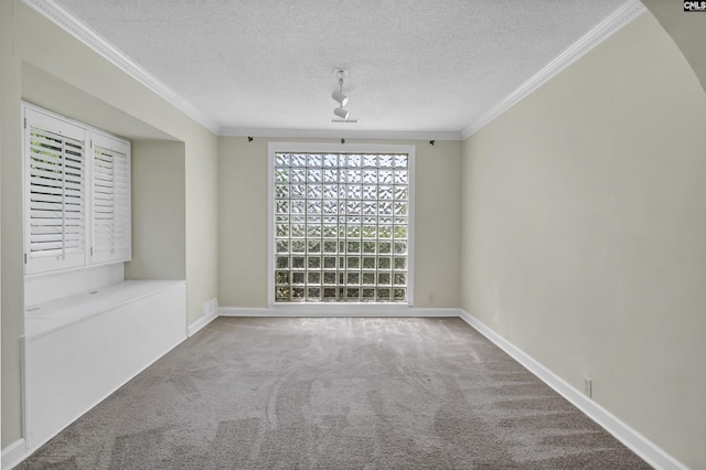 carpeted spare room featuring a textured ceiling, baseboards, and crown molding