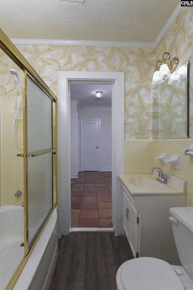 full bath with crown molding, toilet, wainscoting, a textured ceiling, and wallpapered walls