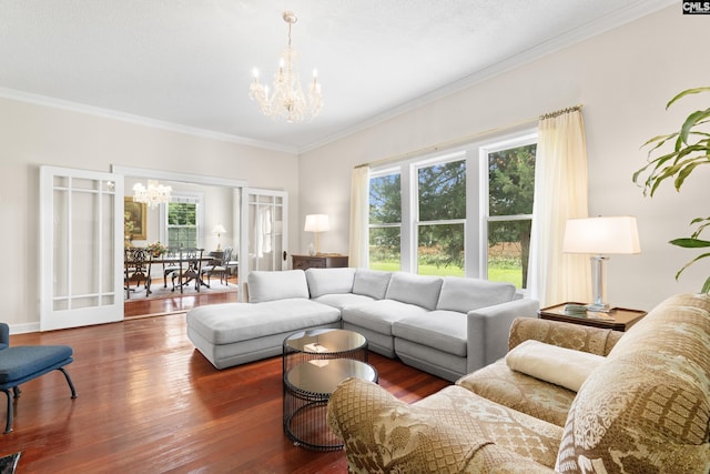 living room with crown molding, dark hardwood / wood-style floors, and a chandelier