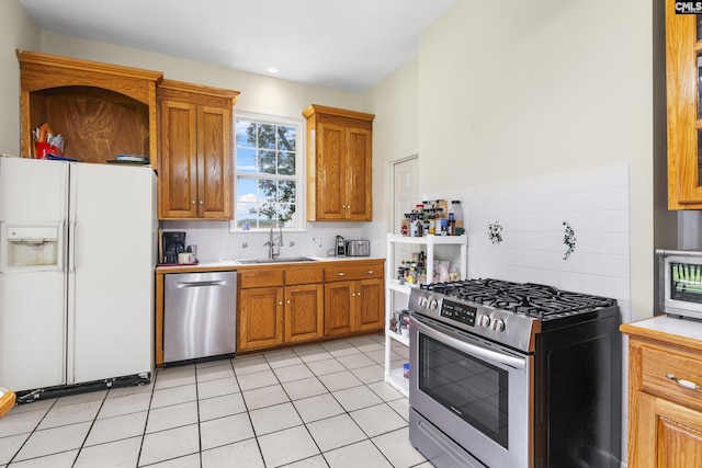 kitchen featuring tasteful backsplash, stainless steel appliances, sink, and light tile patterned floors