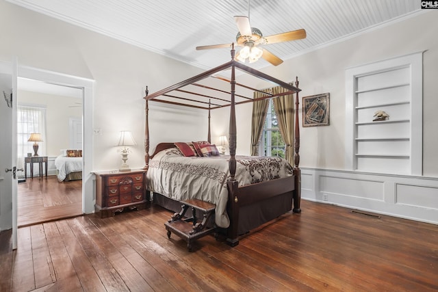 bedroom with crown molding, dark hardwood / wood-style floors, and ceiling fan