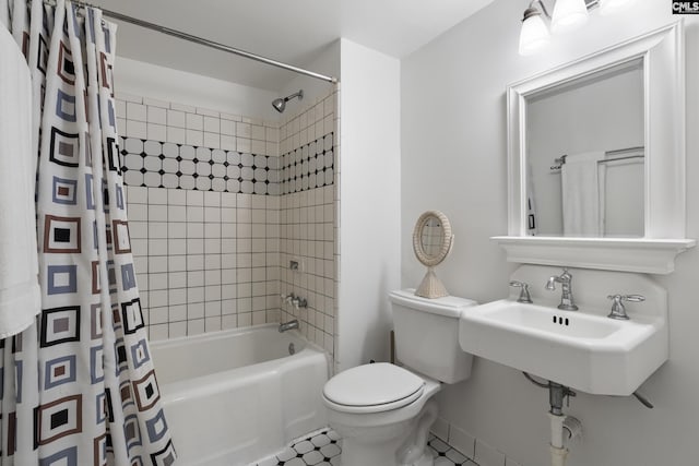 full bathroom featuring sink, shower / bath combination with curtain, and toilet