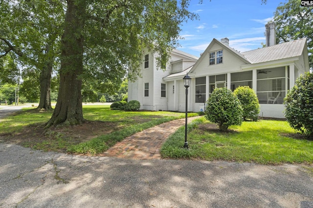 view of front of house with a front lawn and a sunroom