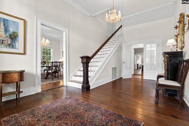 entryway featuring crown molding, dark hardwood / wood-style flooring, and a chandelier