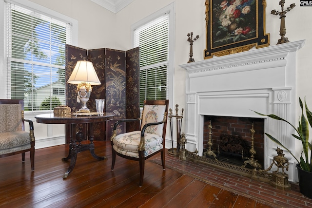 sitting room with hardwood / wood-style flooring, ornamental molding, and a fireplace