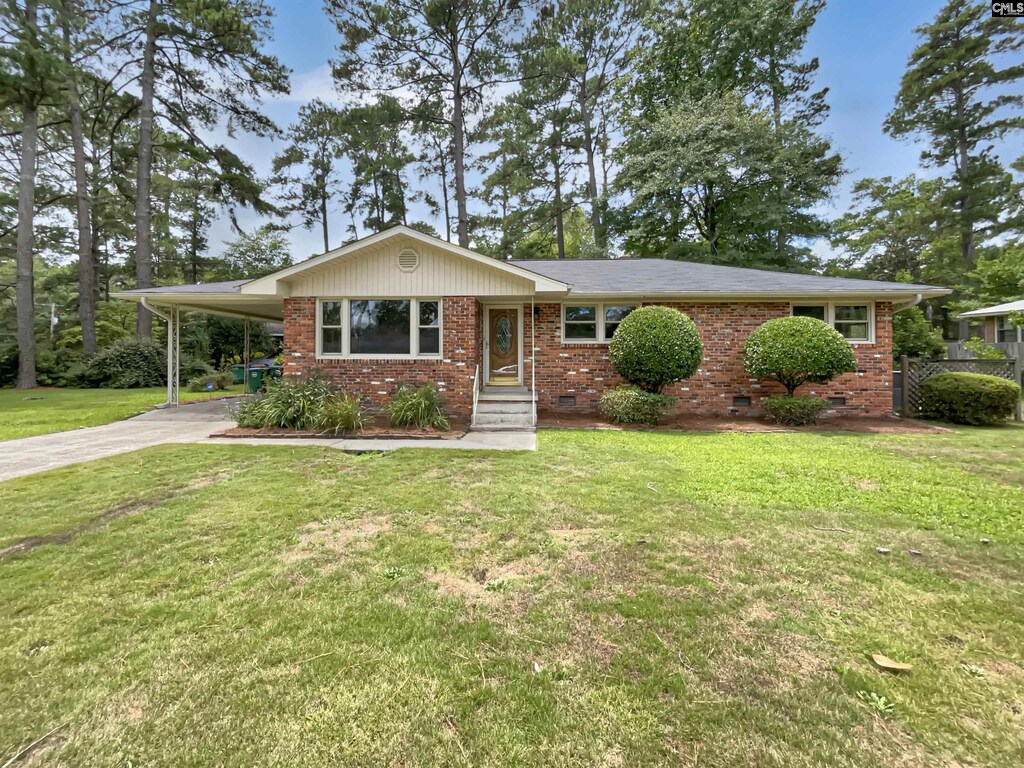 ranch-style house with a carport and a front lawn