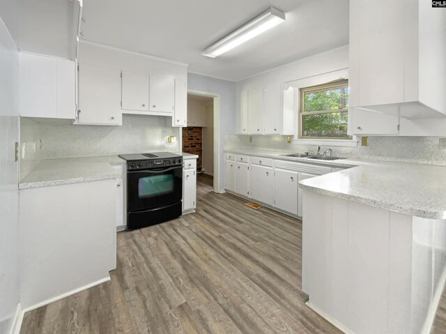 kitchen with light wood-type flooring, sink, black range with electric cooktop, and white cabinets