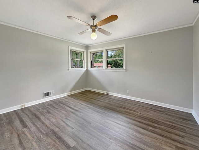 spare room with dark wood-type flooring, ornamental molding, and ceiling fan