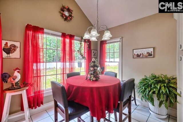 tiled dining room featuring a notable chandelier, a wealth of natural light, and high vaulted ceiling