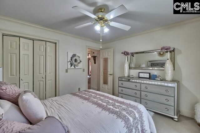 bedroom with a closet, carpet, ceiling fan, and crown molding