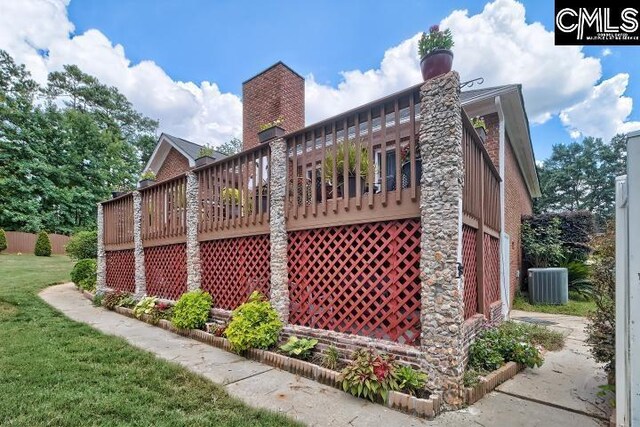 view of home's exterior featuring a lawn, central AC unit, and a deck