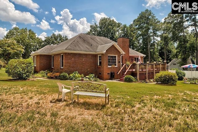 rear view of house featuring a deck and a lawn