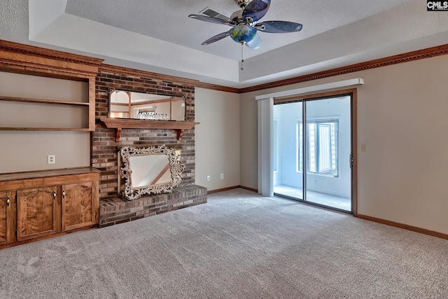 unfurnished living room featuring light colored carpet, a brick fireplace, a textured ceiling, a raised ceiling, and ceiling fan