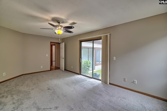 empty room with ceiling fan, light carpet, and a textured ceiling