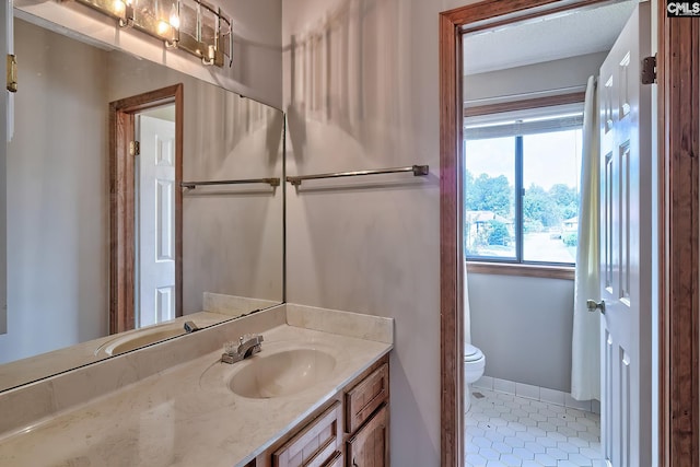 bathroom featuring vanity, tile patterned floors, and toilet