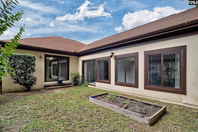 rear view of house featuring a yard